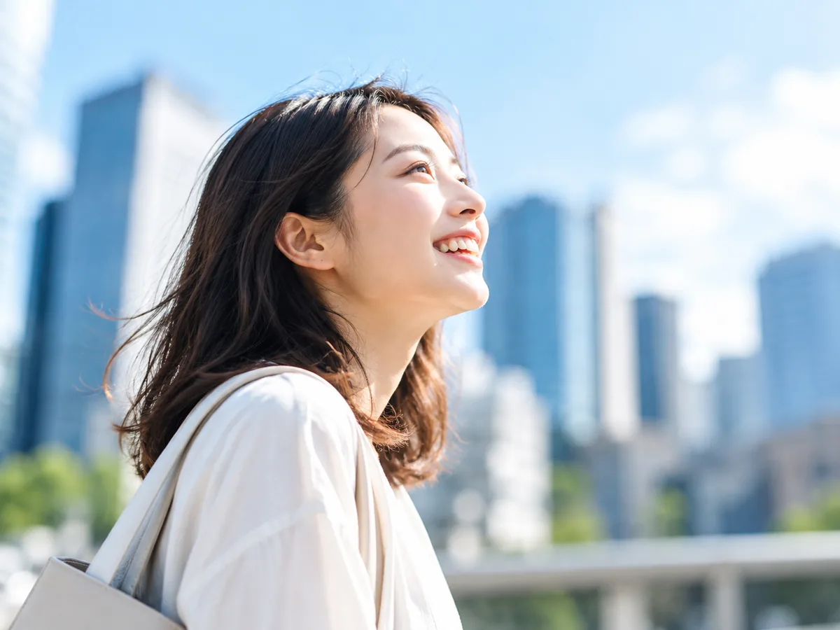 街を見上げて笑う女性（イメージ）